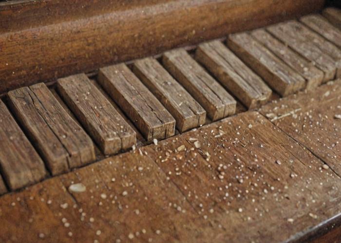 Piano refinishing process showing wood restoration work